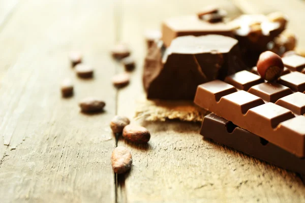 Still life with set of chocolate with nuts on wooden table, closeup — Stock Photo, Image