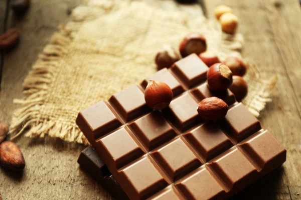 Натюрморт з набором шоколаду з горіхами на мішковині, крупним планом — стокове фото