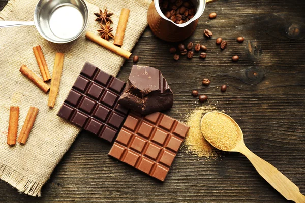 Stilleben med uppsättning av choklad med kryddor på trä bakgrund — Stockfoto