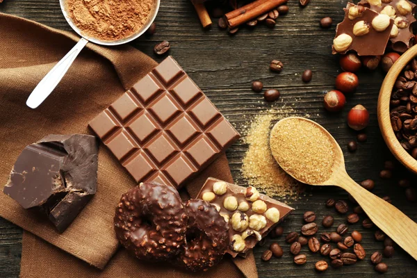 Csendélet sorozata a csokoládé, a dió és a fűszerek, a fából készült asztal, felülnézet — Stock Fotó