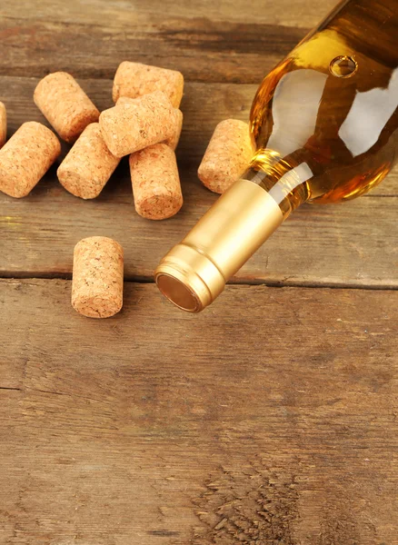 Botella de vino con corchos sobre fondo de mesa de madera —  Fotos de Stock