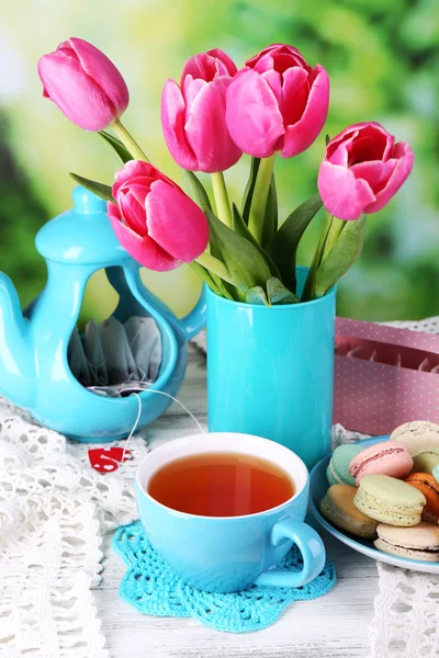 Komposition von Frühlingsblumen, Tee und Keksen auf dem Tisch vor natürlichem Hintergrund — Stockfoto