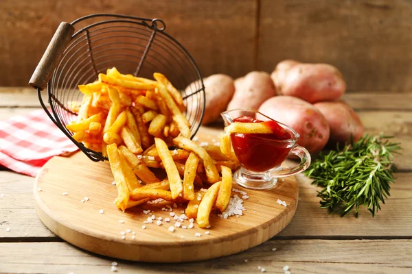 Leckere Pommes in Metallkorb auf Holztischhintergrund — Stockfoto