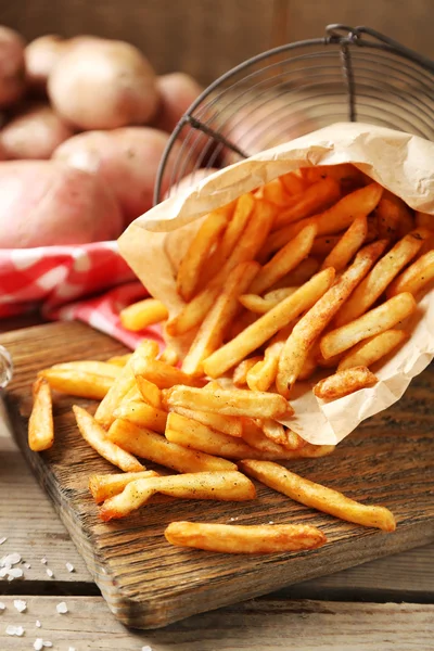 Tahtada patates kızartması, ahşap masa arkasında.
