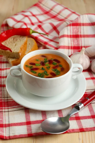 Sopa de frijol en tazón con pan fresco en rodajas en servilleta, sobre fondo de mesa de madera —  Fotos de Stock