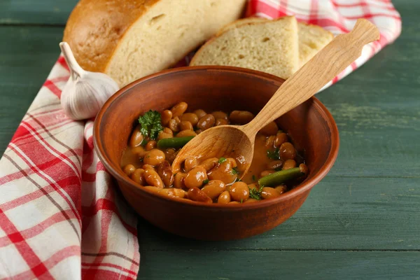 Sopa de frijol en un tazón sobre una servilleta, sobre un fondo de mesa de madera —  Fotos de Stock