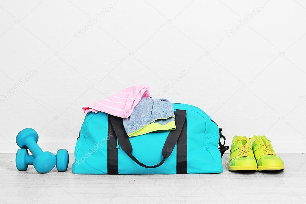 Sports bag with sports equipment in room