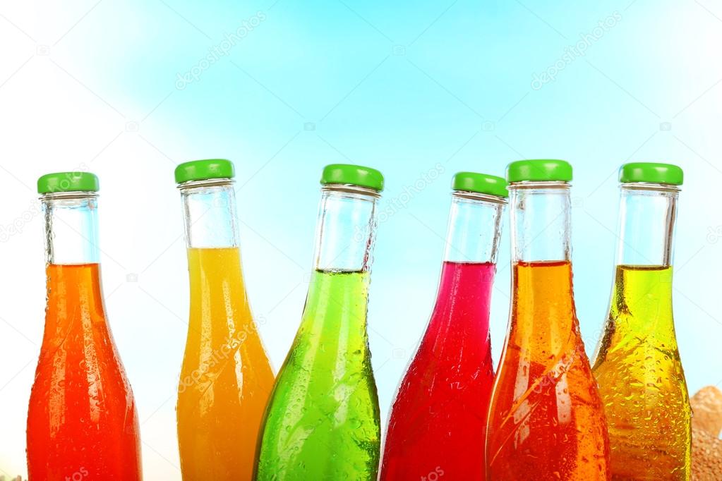 Bottles of tasty drink on bright background