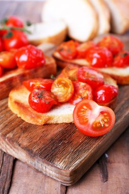 Beyaz dilim tost ekmeği kesme tahtası üzerinde ahşap masa, closeup konserve domates ile