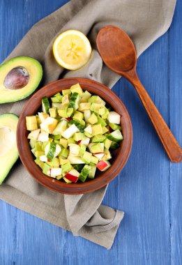 Elma ve kase peçete ahşap arka plan üzerinde Avokado salatası