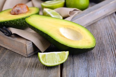 Limes tepsi ahşap arka plan üzerinde avokado