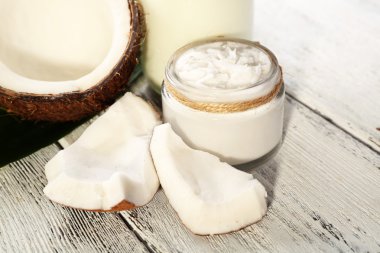 Cam renk ahşap masa arka plan üzerinde taze hindistan cevizi yağı