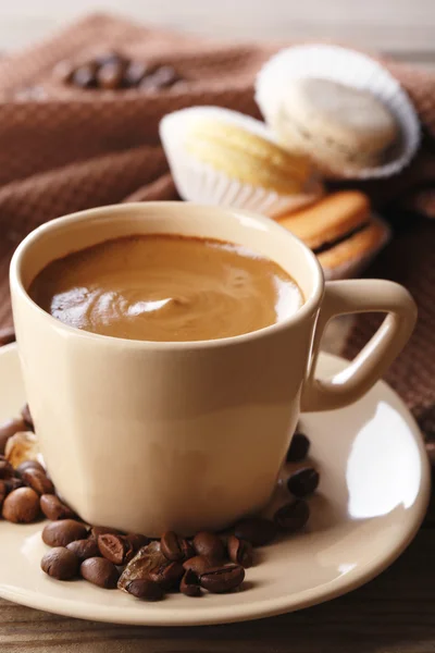 Macarons colorés doux et café en tasse sur fond de table en bois — Photo