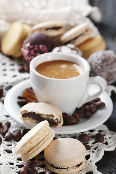 Makaroni yang lembut dan berwarna-warni dan kopi dalam cangkir pada latar belakang meja kayu — Stok Foto