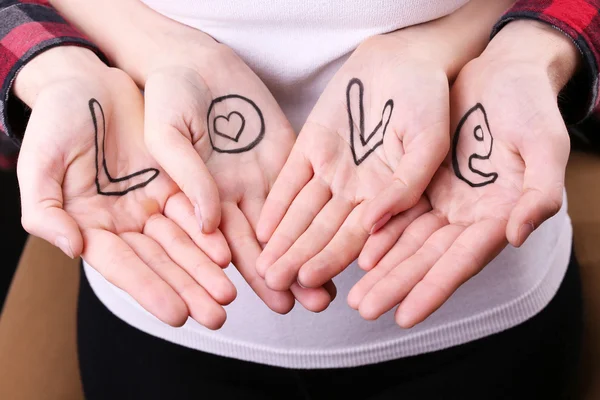 Hands of couple with inscription Love, close-up view — Stock Photo, Image