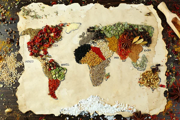 Mapa del mundo hecho de diferentes tipos de especias sobre fondo de madera — Foto de Stock