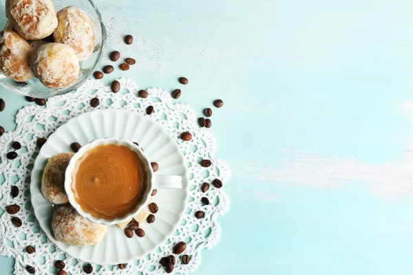 Tasse Kaffee und leckeres Gebäck auf farbigem Holzhintergrund — Stockfoto