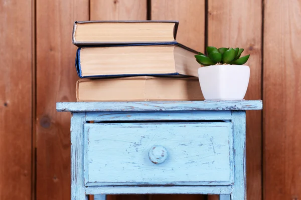 Desain interior dengan tanaman dan tumpukan buku di atas meja pada papan kayu latar belakang — Stok Foto
