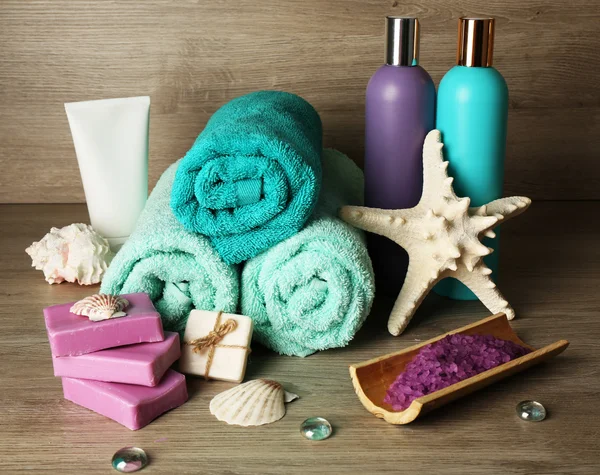 Spa samenstelling met handdoeken en zeezout op houten achtergrond — Stockfoto