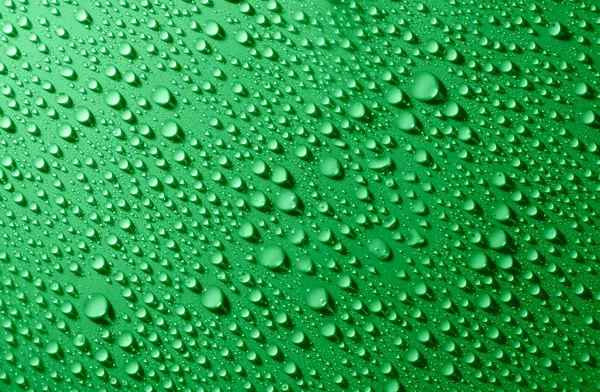 Wassertropfen auf Glas auf grünem Hintergrund — Stockfoto