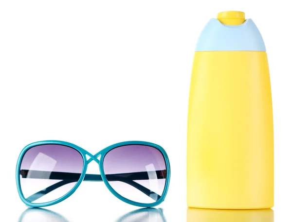 Botella de crema bronceadora con gafas de sol aisladas en blanco — Foto de Stock