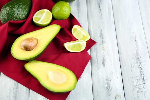 Aguacate con limas en servilleta sobre fondo de madera —  Fotos de Stock