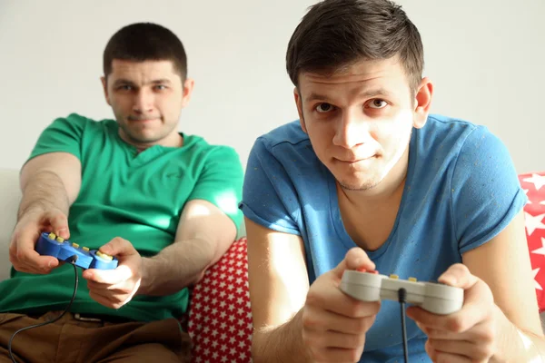 Dwóch przystojnych mężczyzn grając w gry wideo w pokoju — Zdjęcie stockowe