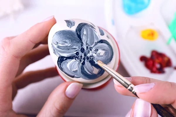 Young woman painting Easter eggs on table close up — Stock Photo, Image