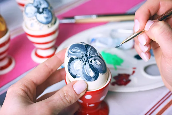 Young woman painting Easter eggs on table close up — Stock Photo, Image