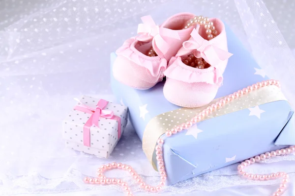 Pink baby boots with gift close-up — Stock Photo, Image