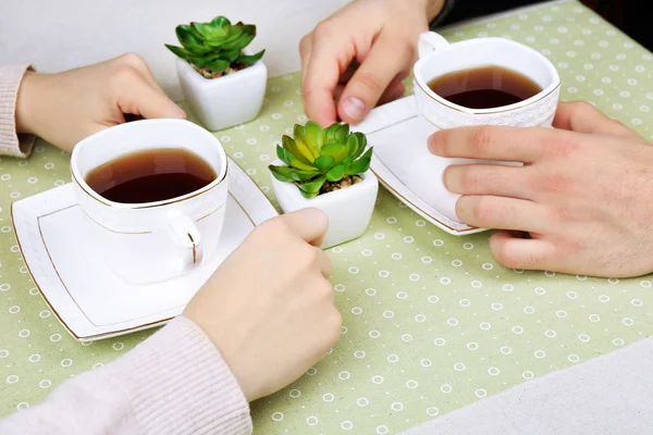 Manos femeninas y masculinas con tazas de té, primer plano — Foto de Stock