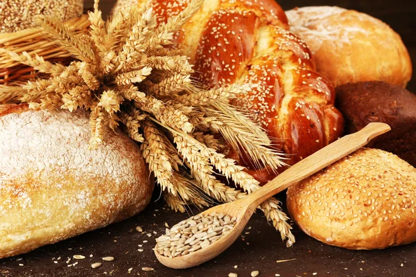 Different bread with ears and sunflower seeds on wooden background Stock Picture