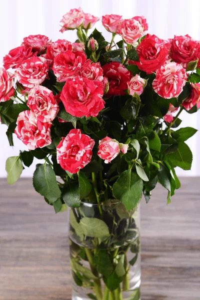 Hermosas rosas en jarrón en la mesa sobre fondo claro — Foto de Stock