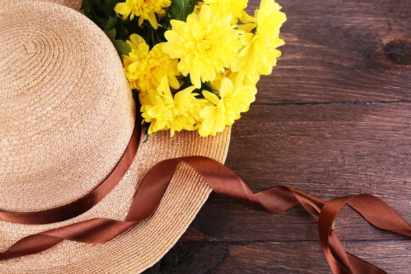 Chapeau avec des fleurs sur fond en bois — Photo