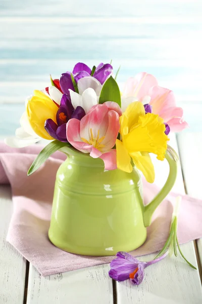 Beautiful spring flowers on wooden table on blue background — Stock Photo, Image