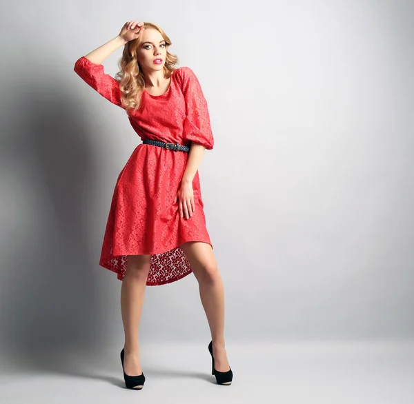 Beautiful young woman in color dress posing on light background — Stock Photo, Image