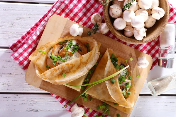 Frittelle con funghi cremosi sul tagliere sul tavolo di legno, vista dall'alto — Foto Stock