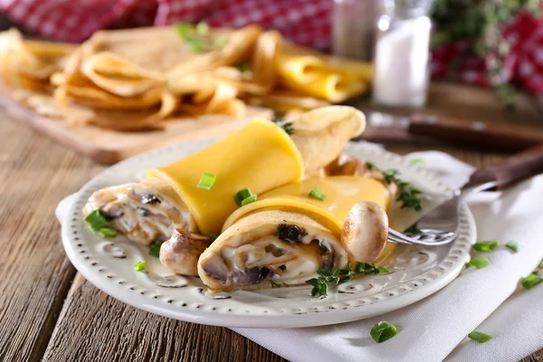 Pannkakor med krämig svamp i plattan på träbord, närbild — Stockfoto