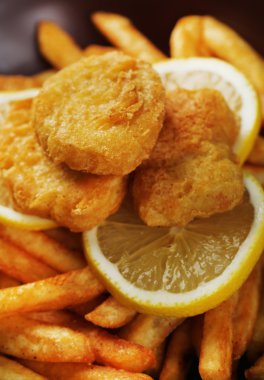 Kızarmış tavuk nuggets ve dilimlenmiş limon, makro görünümü ile patates tava