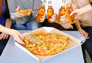 Arkadaşlar el ile şişe bira ve pizza, yakın çekim