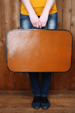 Eski çanta ahşap arka plan üzerinde tutan kadın