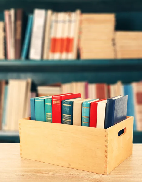 Livres en caisse en bois sur fond de bibliothèque — Photo