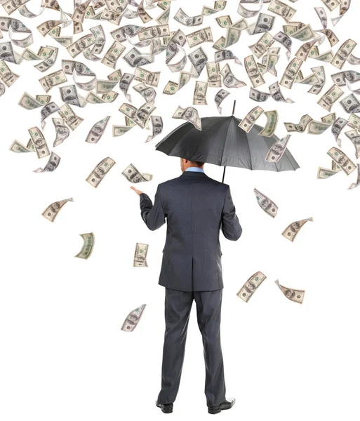 Бизнесмен, стоящий под дождем денег — стоковое фото