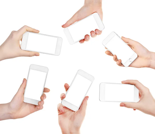 Manos sosteniendo teléfonos inteligentes aislados en blanco —  Fotos de Stock