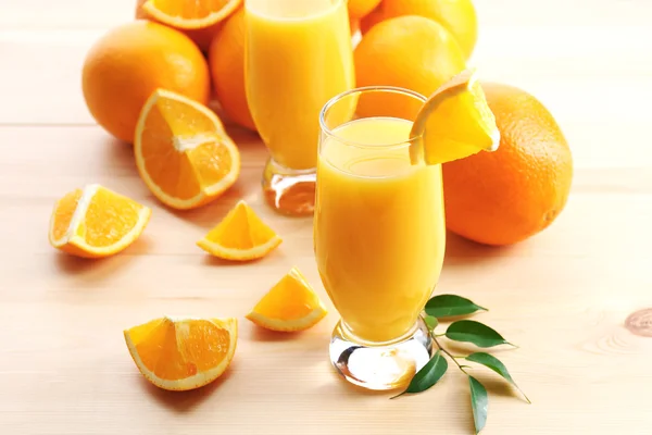 Jugo de naranja recién exprimido en mesa de madera —  Fotos de Stock