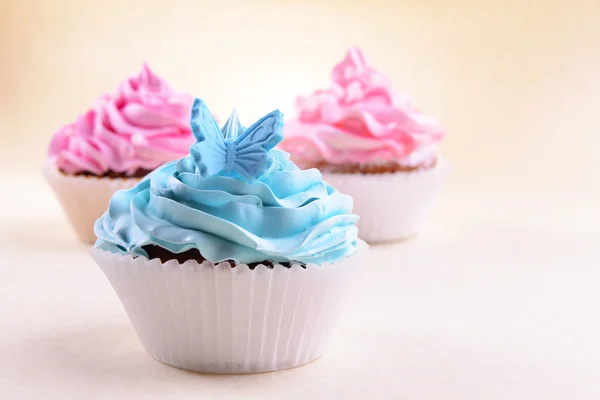 Deliciosos cupcakes no fundo bege — Fotografia de Stock