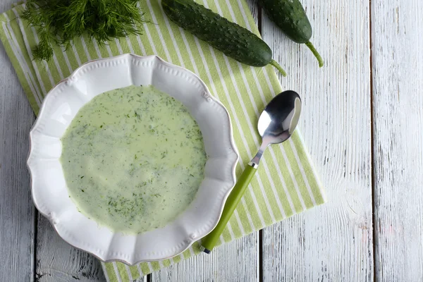 Cucumber soup in bowl on color wooden table background — Stock Photo, Image