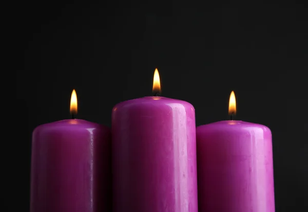 Fialové svíčky na černém pozadí — Stock fotografie