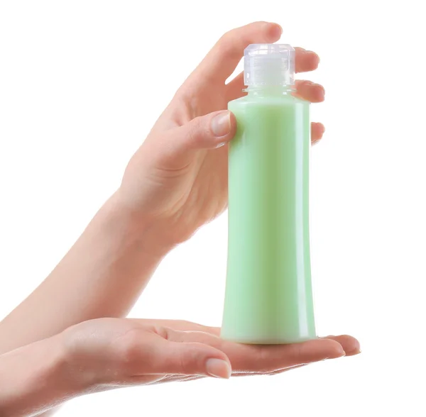 Kvinnliga händer med kosmetika flaska isolerad på vit — Stockfoto