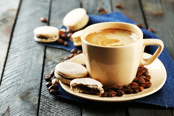 Gentle colorful macaroons and  coffee in mug on wooden table background — Stock Photo, Image